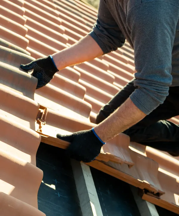 a roofer installing interlocking roof tiles