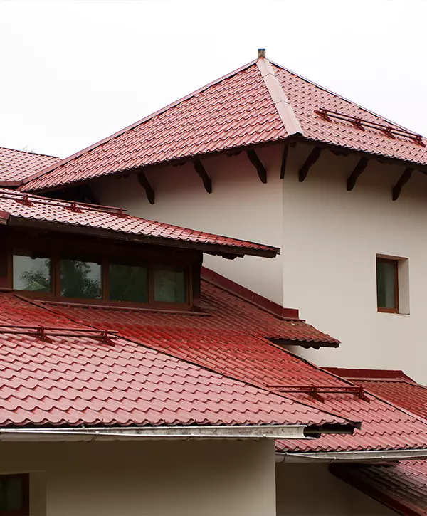 Exterior of a multi-level home featuring distinct red clay tiles installed during a recent roof replacement.