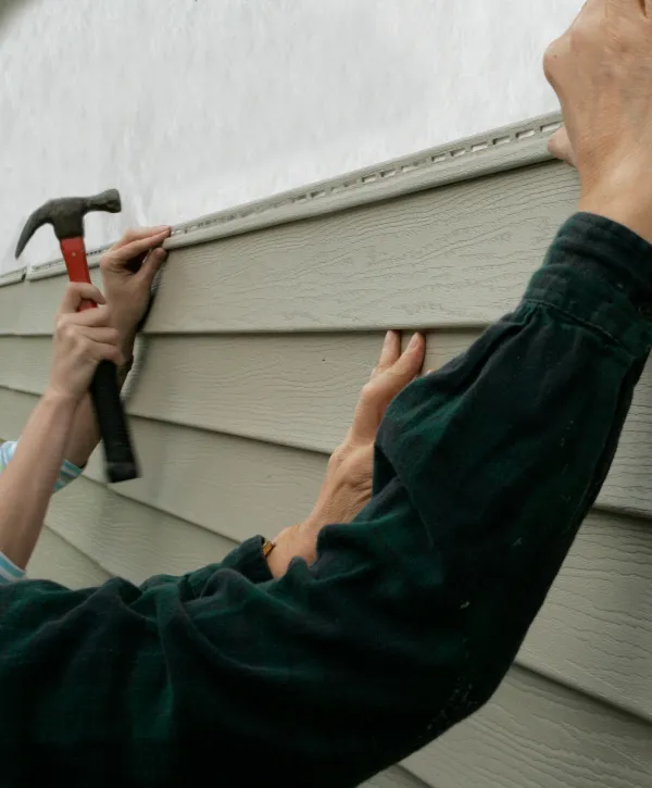 workers installing vinyl siding during a siding replacement project