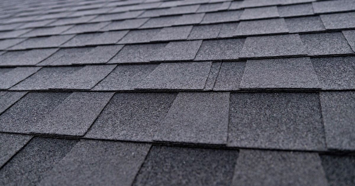 Close-up detailed view showing the granular texture and composite layers of modern asphalt roof shingles.