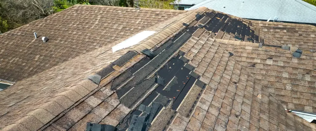 Construction crew performing a full roof replacement on a suburban home.