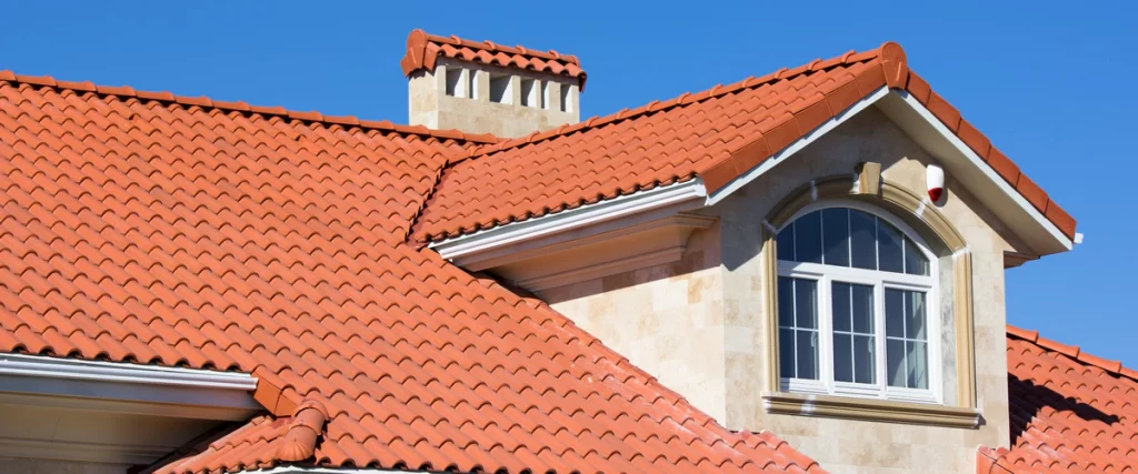 Classic Mediterranean style traditional terra cotta clay tile roof under a clear sky.