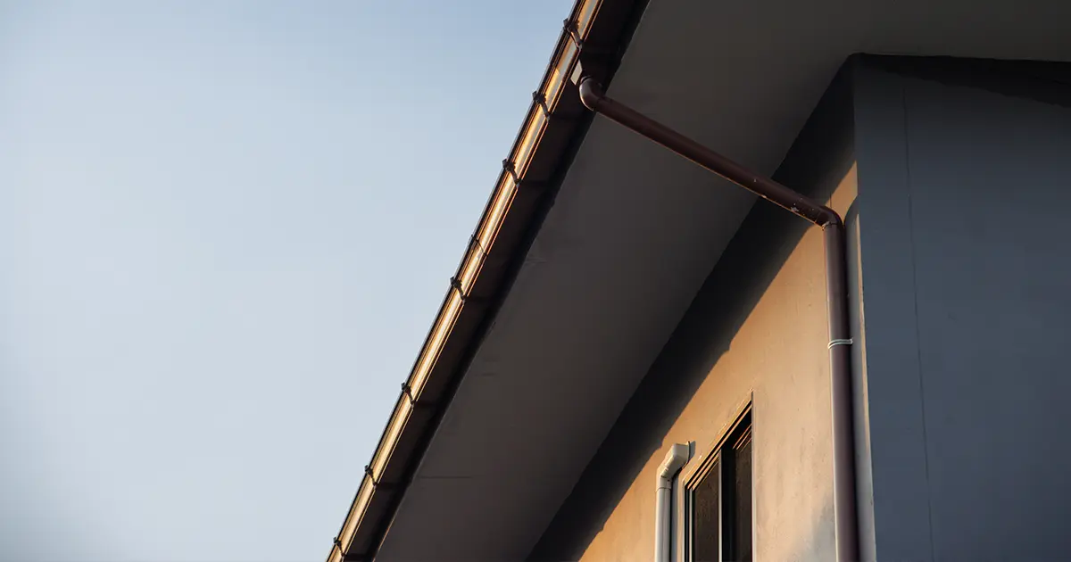 Seamless gutter and downspout installation on modern home for effective rainwater drainage